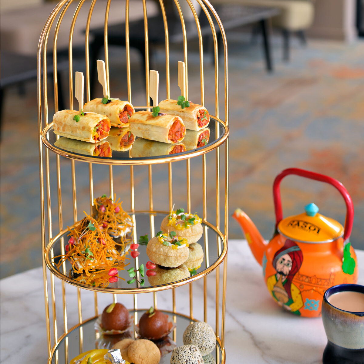 Gold tiered birdcage stand presenting gourmet canapes and sweets for an H-Gourmet high tea