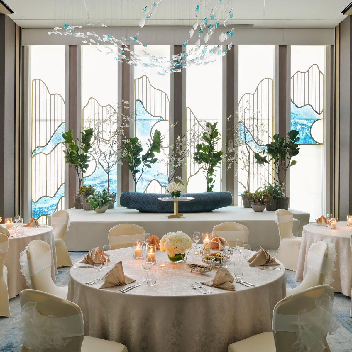 Elegant ballroom banquet setup with round tables and floral centerpieces at an H-Gourmet event